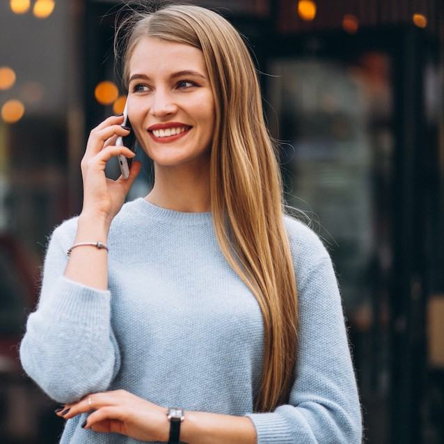 Woman smiling while talking on her mobile phone