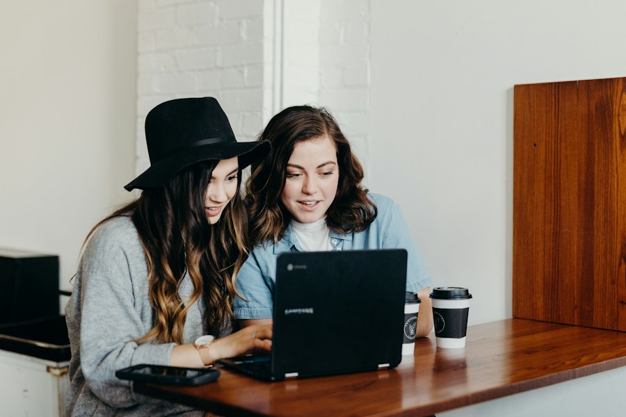 Two women working on a laptop in a café